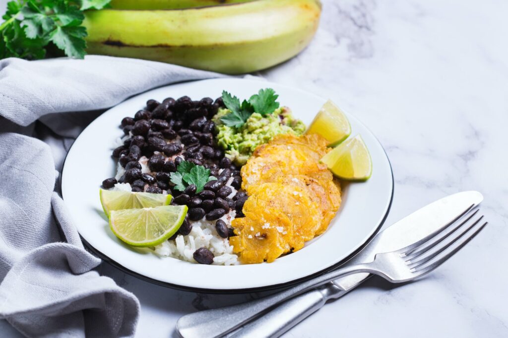 Rice with black beans, fried tostones, plantains, guacamole sauce