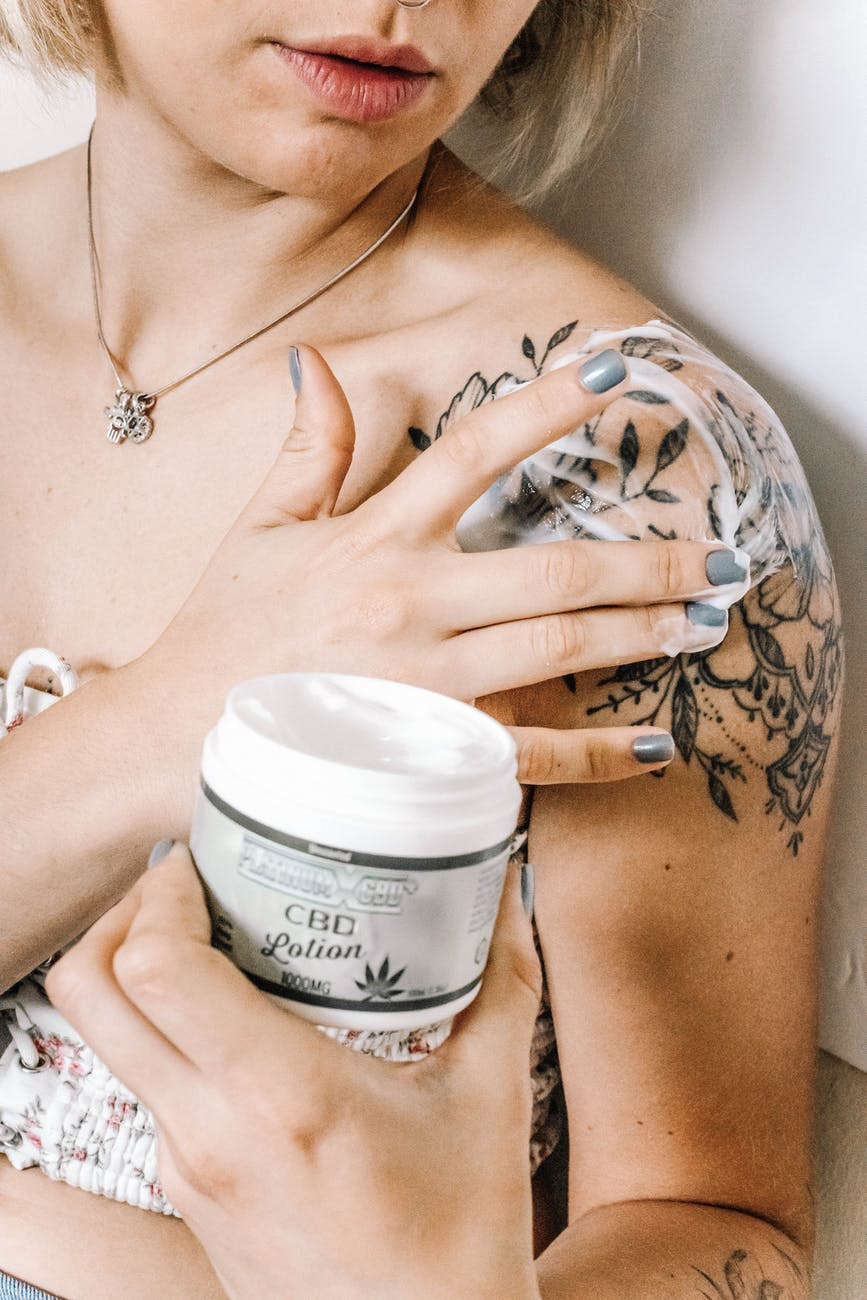 woman putting cbd lotion on skin