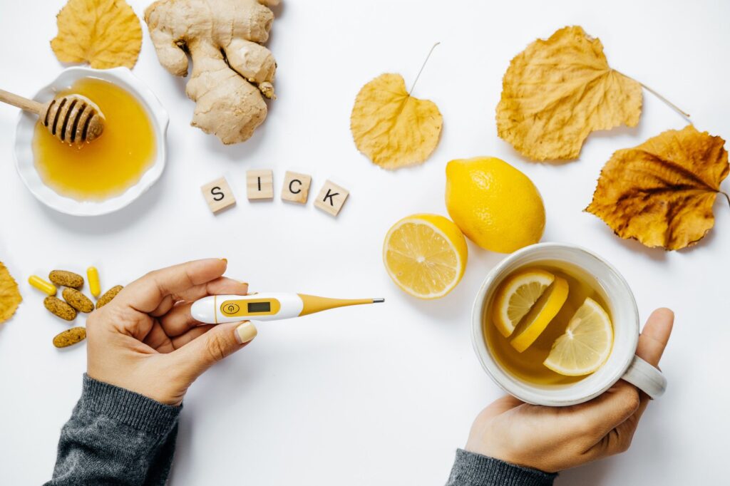 Female hands with tea, Wooden word sick, lemon
