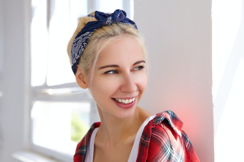 Portrait of young cheerful blonde female with casual hairstyle wearing headband