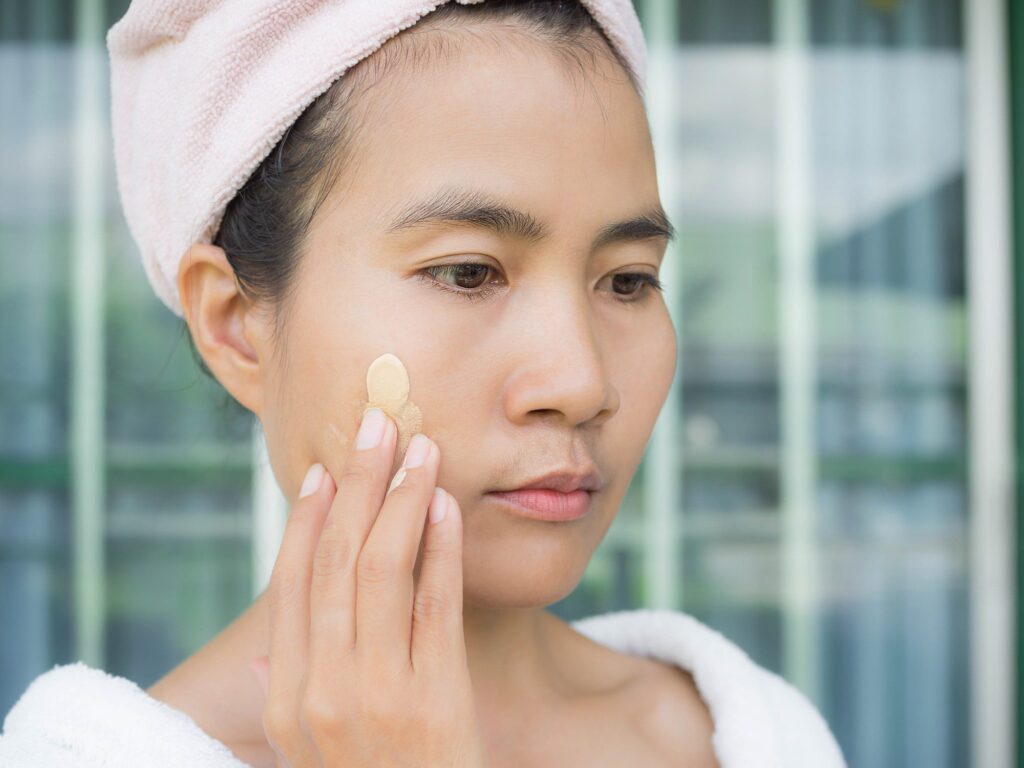 Asian woman apply sunscreen