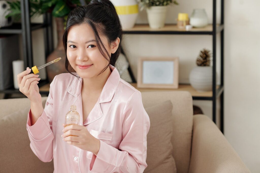 Woman applying serum with vitamin c