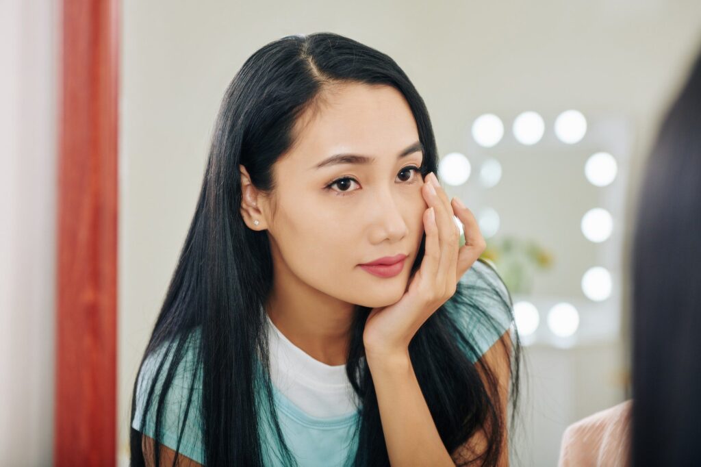 Asian Woman applying under eye cream