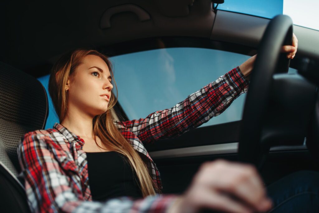 Young woman drives a car