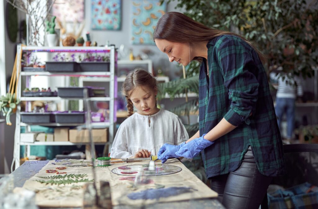 Young happy confident florist is working with her female kid