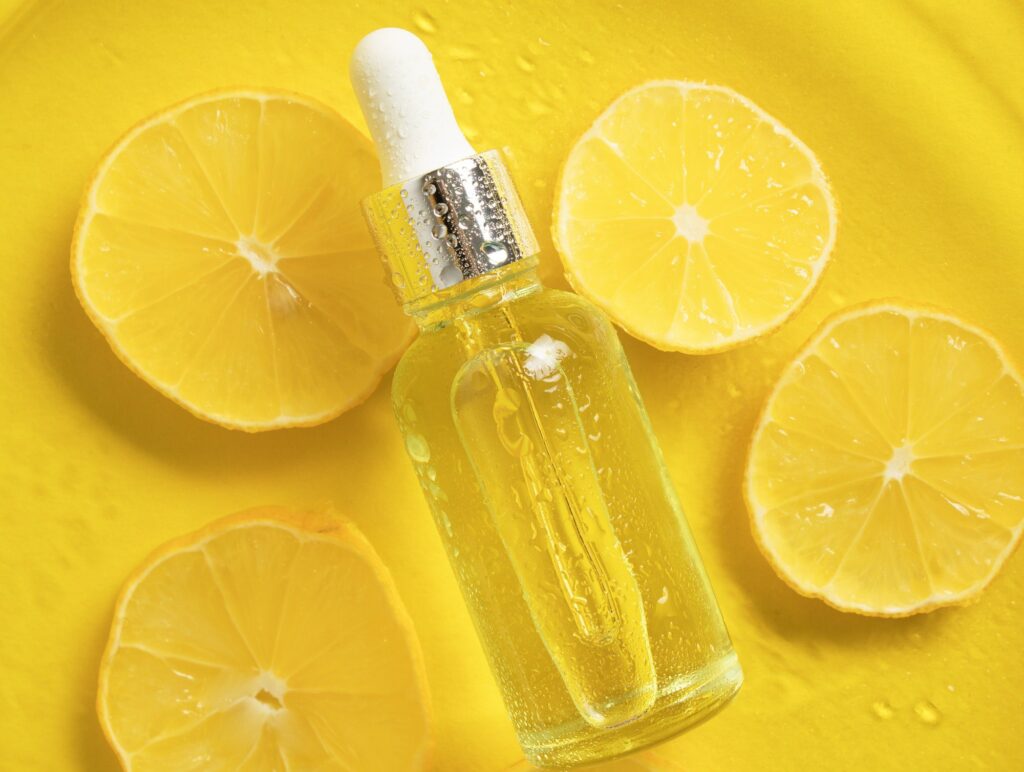 Cosmetic bottle product serum vitamin C with lemon slices.
